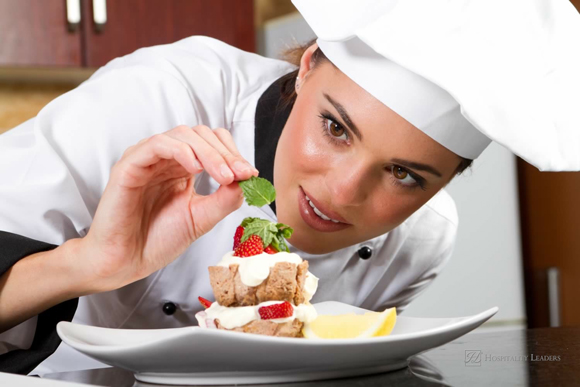 Beautiful young chef decorating delicious dessert