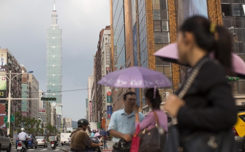 The Taipei 101 skyscraper looms over pedestrians in Taipei. It draws thousands of mainland visitors a day. Photo: Bloomberg